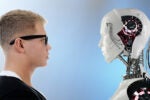 A person with glasses faces a humanoid robot in profile view, symbolizing the interaction between humans and technology.