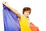 A person in a yellow shirt holding a French flag on a white background.
