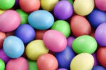 A collection of colorful, pastel Easter eggs in various shades of pink, blue, green, purple, and yellow.