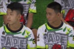 Two young individuals seated and wearing colorful jerseys with graphic designs.