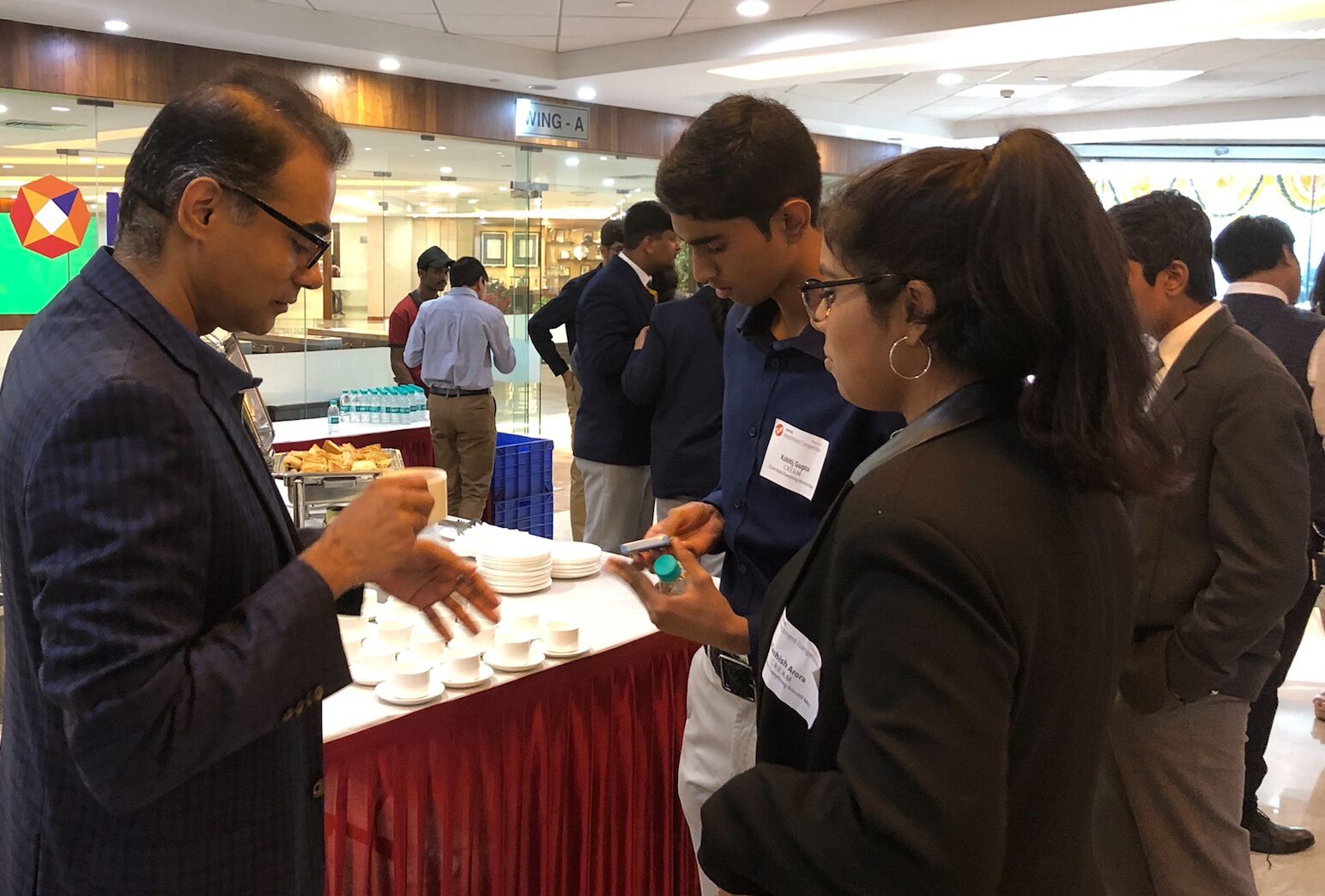 Judge Rajesh Sehgal (left) talks to members of the team CREAM (Cash Rules Everything Around Me).