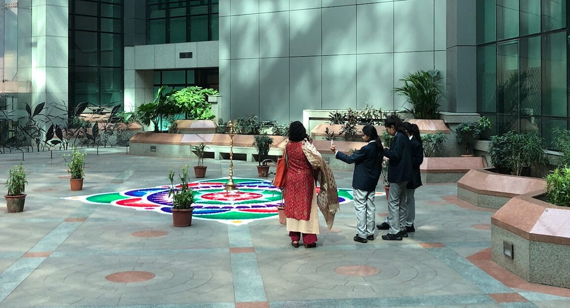 Students and their advisor admire the specially designed rangoli in the NSE atrium. 