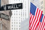 Street signs for Wall Street and Broad Street with American flags in the background, representing the financial district in New York City.
