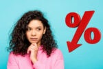 A thoughtful person in a pink hoodie stands next to a large, red downward-facing percentage symbol, suggesting financial or percentage reduction themes.