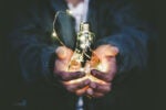 Hands holding a light bulb filled with glowing string lights, symbolizing creativity and inspiration.