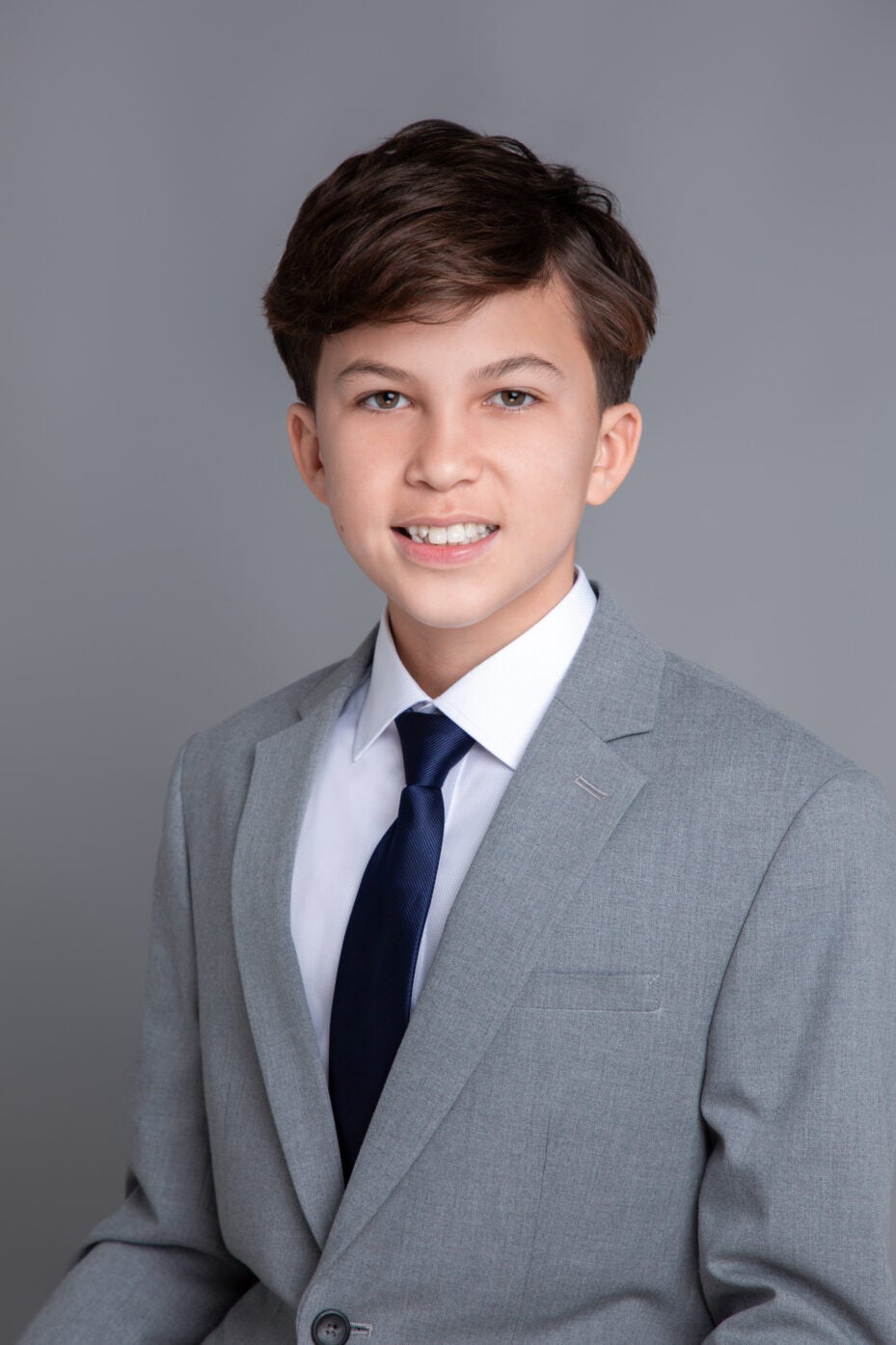 dark-haired boy with white shirt, black tie and grey suit.