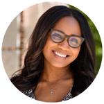 Chelsey Thompson Headshot Headshot of a person with long, dark hair and glasses, smiling in an outdoor setting.