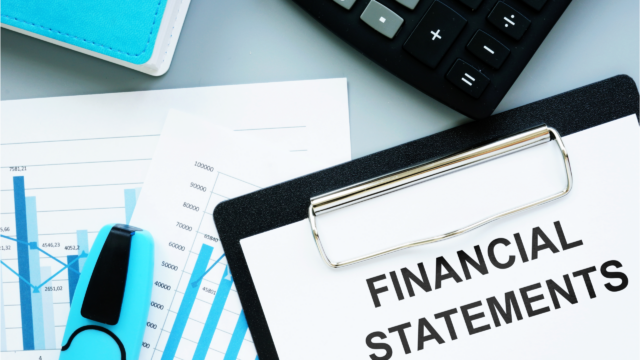 A clipboard with the words "Financial Statements," a calculator, charts, and a highlighter, representing financial analysis or accounting work.